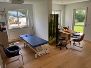 Heller Behandlungsraum der Ergotherapie Jobst in Neumarkt mit Therapieliege und Übungsmaterialien